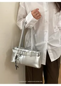 Nahaufnahme der silbernen Schultertasche mit breiter Schnalle und Perlenquasten