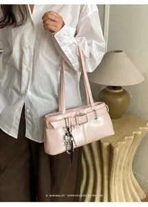 Detailansicht der rosa glänzenden Ledertasche mit Schnalle und dekorativer Fransenkette