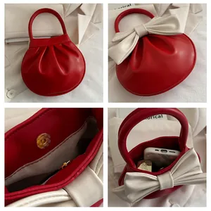 Dettaglio borsa tonda rossa con fiocco avorio, chiusura magnetica e spazio interno ampio