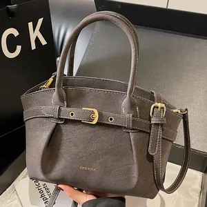 Deep brown leather handbag with textured lychee grain and gold hardware accents