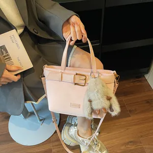 Borsa a mano rosa in ecopelle con cinturino decorativo e ciondolo morbido
