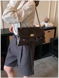 Close-up of brown quilted oil wax leather tote bag with gold metal chain straps