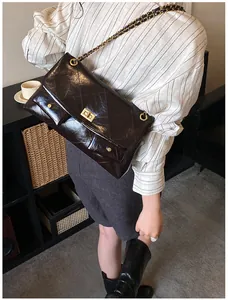 Close-up of brown quilted leather tote with gold chain strap and metal turn-lock