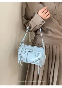 Detail of light blue retro pillow bag featuring twin zipper pockets and metal buckle strap