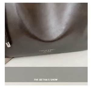 Close-up of textured dark brown leather tote bag with elegant silver brand lettering