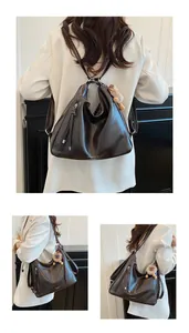 Detail of dark brown leather tote with plush bear charm and versatile shoulder straps