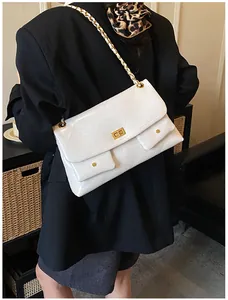 Close-up of white quilted leather tote bag with gold chain and dual pocket details