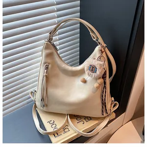 Detail view of beige retro multi-way backpack with tassel zipper and sheep plush charm