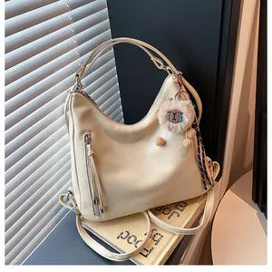 Detail of cream white leather tote with vertical zipper and plush alpaca charm