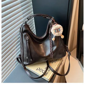Detail of dark brown hobo bag with leather texture and vertical zipper decoration