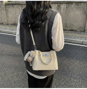 Macro shot of cream lychee leather texture and silver twist lock on bucket bag
