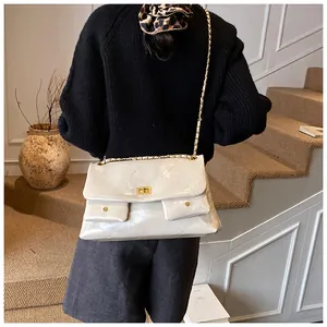 Detail of quilted beige leather tote bag with gold chain strap and dual pockets
