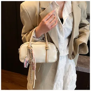 Détail du sac Boston blanc crème en cuir PU avec fermoir sphérique décoratif