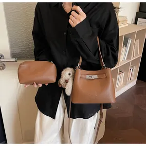 Brown lychee leather bucket bag set with metal buckle detail and cute plush bunny charm