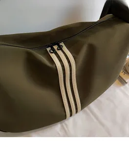 Gros plan du sac bandoulière vert olive en tissu texturé avec double fermeture