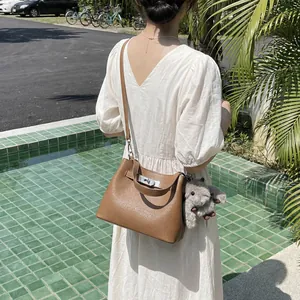 Brown lychee leather bucket bag with silver lock and cute koala charm for daily commute