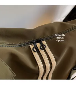 Détail macro du sac bandoulière olive avec double fermeture éclair fluide en métal