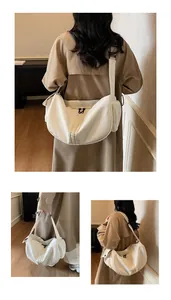 Détail du grand sac bandoulière en toile blanche montrant la poche latérale et la sangle