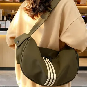 Sac bandoulière demi-lune en nylon vert olive avec trois bandes blanches et sangle