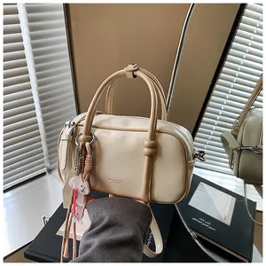 Détail du sac Boston avec logo MOJO & BAGS, poignée à perles et breloque décorative