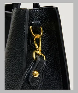 Detailed close-up of premium lychee grain leather texture and glossy gold hardware