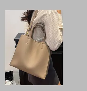 Detailed view of khaki lychee grain leather tote bag with brand logo at the base