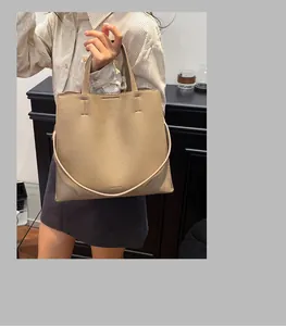 Detail of khaki litchi grain tote bag showing textured leather and embossed chic lettering