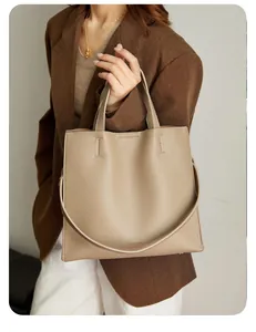 Detail of taupe lychee grain leather tote bag with embossed TANGREYA brand logo