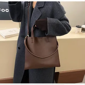 Detail of lychee pattern brown leather tote bag with handle and crossbody strap