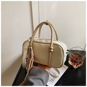 Vue rapprochée d'un sac à main Boston beige avec charms décoratifs et poignées