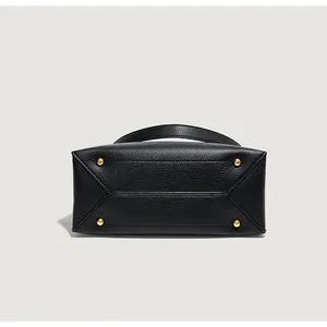 Detail view of the black lychee pattern leather bag bottom with four golden protective studs