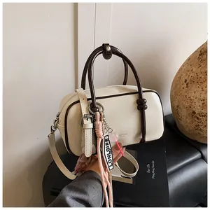 Détails du sac Boston rétro avec poignées contrastées et breloques décoratives