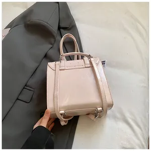 Draufsicht auf rosa Lederrucksack auf grauem Blazer mit Textur und Silberbuckles