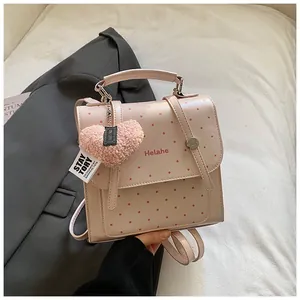 Nahaufnahme von rosa gepunktetem Rucksack mit Herzanhänger und Helahe Markenbranding
