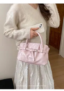 Detail of pink pearlescent handbag with ruched texture and a sophisticated retro vibe