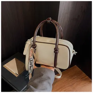 Détail du sac Boston crème avec poignées marron et bandoulière réglable pour femmes