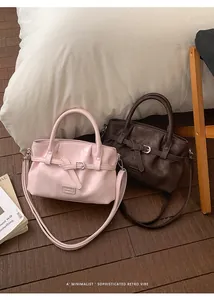Detail view of pink and brown PU leather bucket bags with buckle straps and shoulder straps