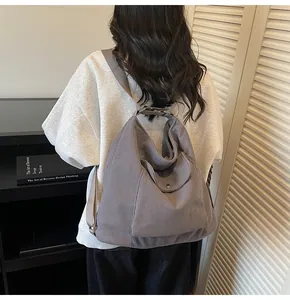 Detail of dark grey corduroy tote backpack showing thick texture and metal snap front pocket