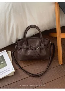 Detail of dark brown leather bucket bag with retro knot and dual round handles