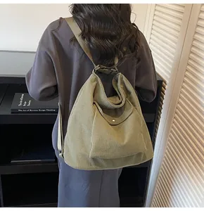 Detail of sage green corduroy convertible backpack with a front flap pocket and texture