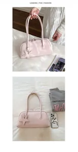 Detail of light pink leather handbag with a star pendant and double zipper closure