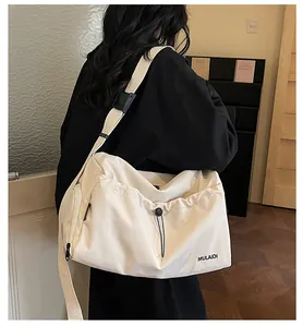 Detail der minimalistischen cremefarbenen Reisetasche mit Gurt und MULAIDI-Logo