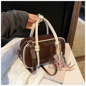 Détail du sac Boston marron et crème avec doubles poignées et charm en tricot