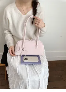 Detail of light pink matte shoulder bag featuring an elegant star charm and zipper closure