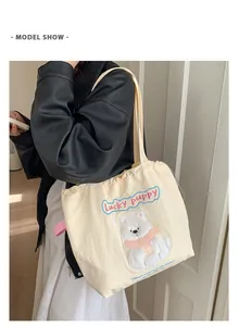 Detaillierte Nahaufnahme einer cremefarbenen Segeltuchtasche mit gesticktem Welpen und Text