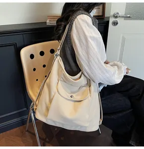 Detail of corduroy tote bag side pocket and adjustable strap on a female model