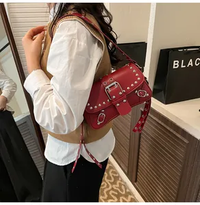 Λεπτομέρεια κόκκινης δερμάτινης τσάντας ώμου με ασημένια τρουκς και λουρί