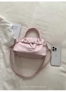 Detailed top view of a pink leather bucket bag with pleats and silver metal hardware