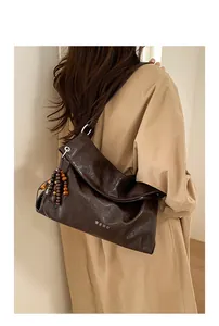 Detail of dark brown pleated tote bag with wooden bead tassel and Korean lettering print