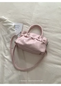 Minimalist soft pink bucket bag with vintage pleats, dual handles and crossbody strap